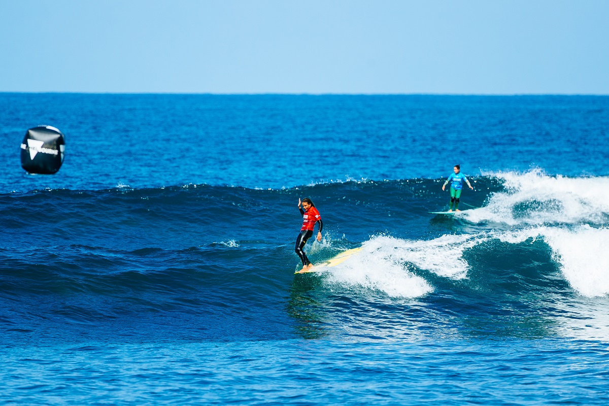 Alice Lemoigne faz um hang ten e Chloé Calmon surfa a onda de trás.